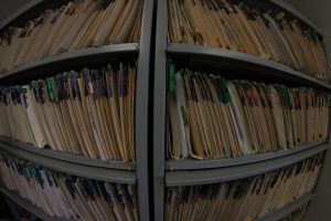 Wide-angle image of shelves of patient files, all with multi-colored tabs